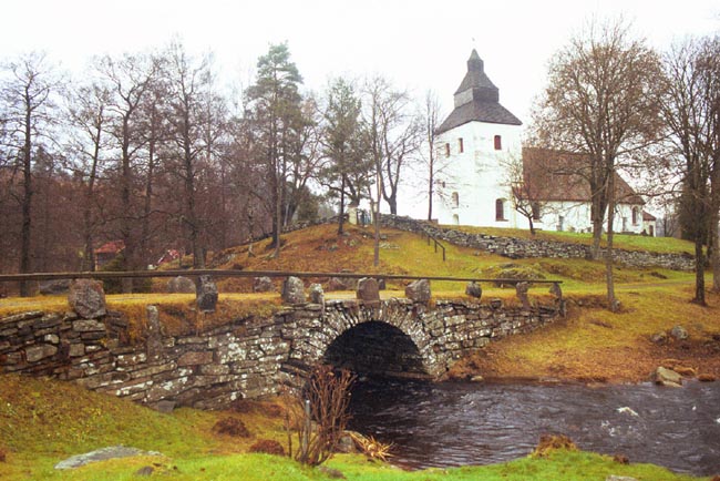 Stenvalvsbro med Hyssna gamla kyrka i bakgrunden.