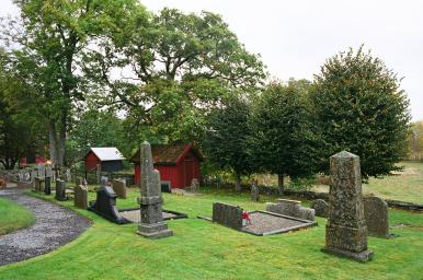 Östra delen av Tostareds kyrkogård med ekonomibyggnaden i nordöstra hörnet, från SV.