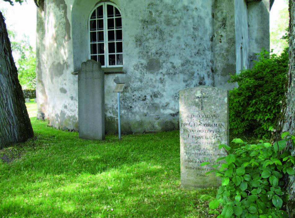 Två äldre gravstenar i sandsten uppställda öster om kyrkan.