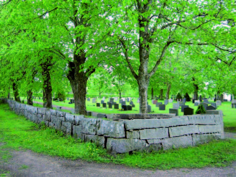 Kyrkogårdsmuren kring den del av kyrkogården som anlades på 1930-
talet. Här ser man att den består av dels nyare stenar som de stenar
som fanns i den gamla kyrkogårdsmuren som revs och återanvändes.
