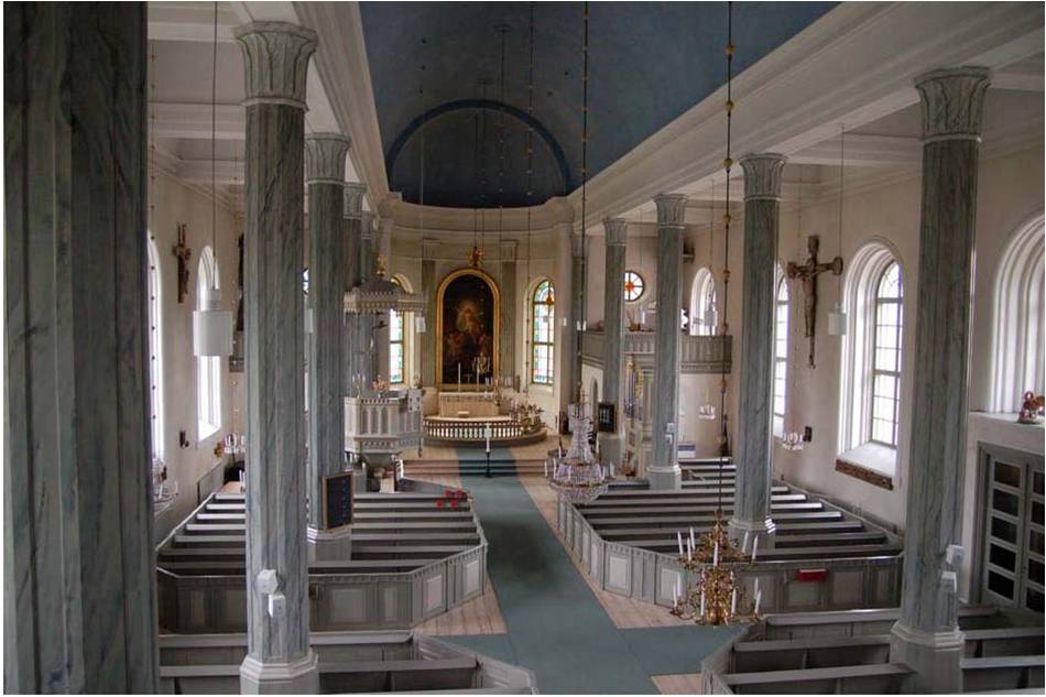 Kyrkorummet sett från orgelläktaren. Den välbevarade inredningen kompletterades på 1930-talet med bland annat ny färgsättning och vindfång vid ingångarna, längst till höger i bild. Det väl sammanhållna rummet får en speciell karaktär av de höga och slanka pelarna. 