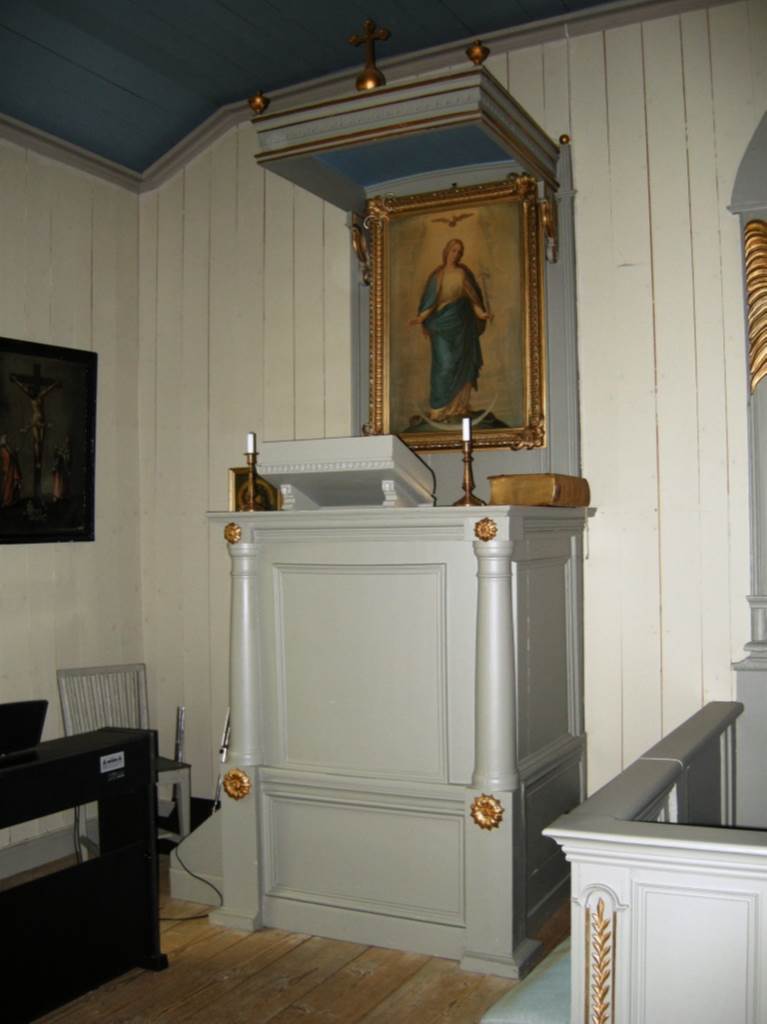 Predikstolen med liten trappa på vänstra sidan. Höger om predikstolen skymtar altarringen.