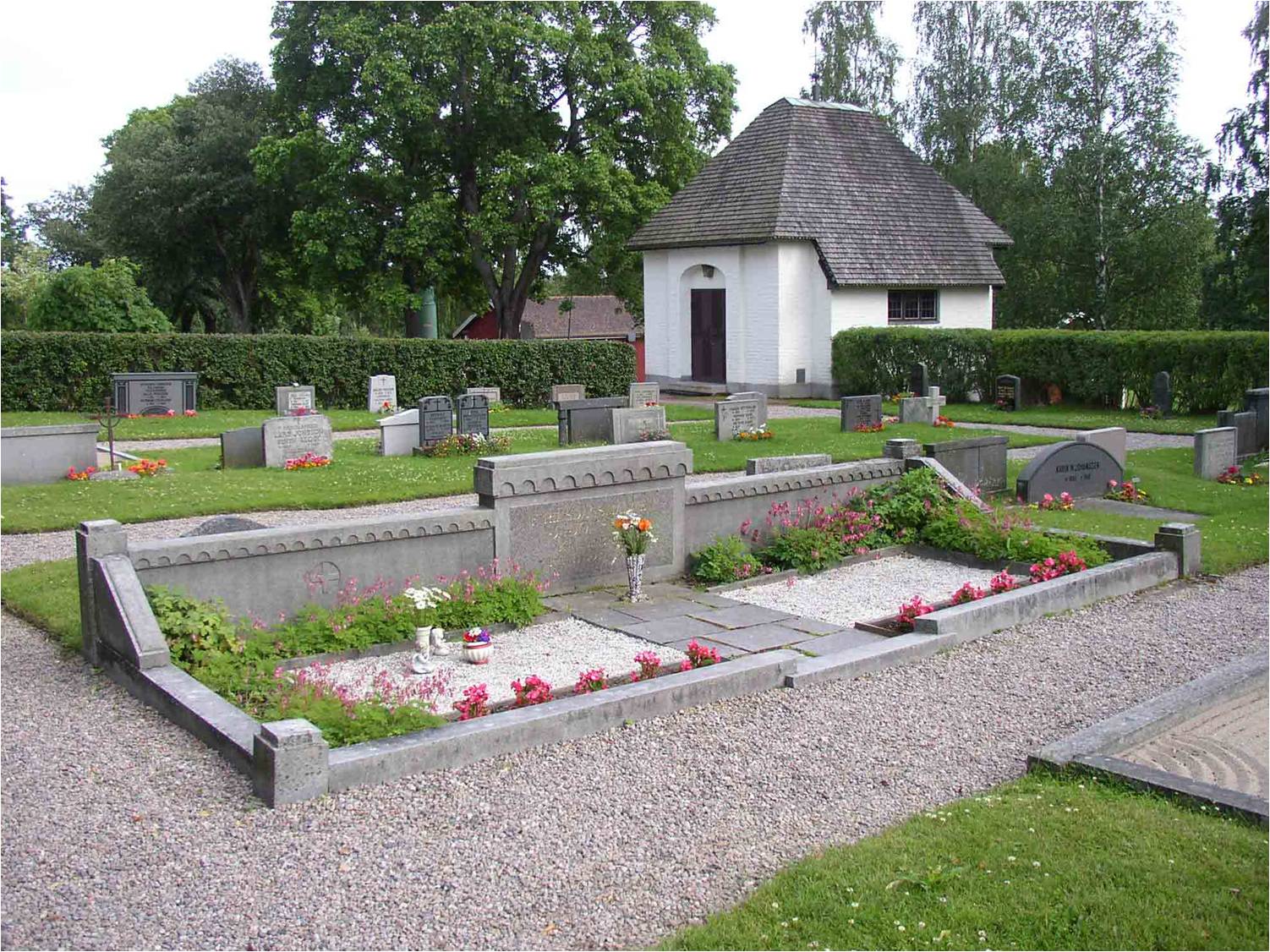 Gravkapellet i bakgrunden och en av de största familjegravarna på kyrkogården i förgrunden. 