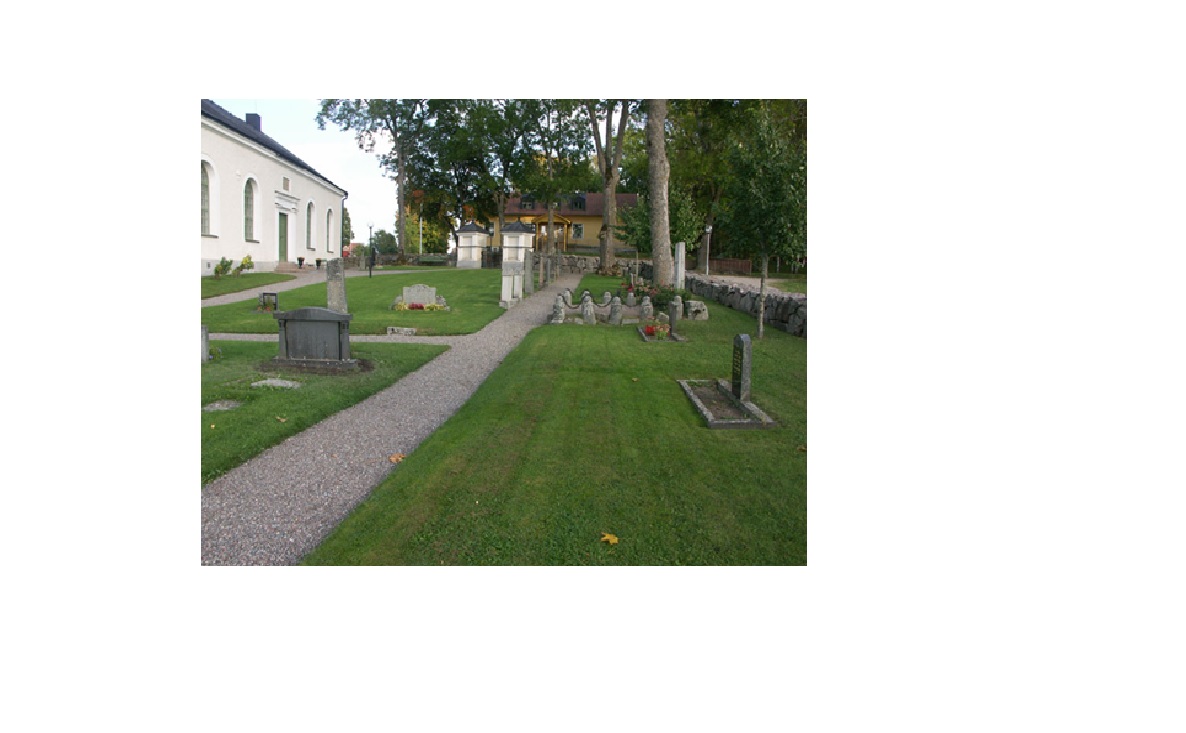 Kyrkogården med gravar av varierande ålder. I bakgrunden skolhuset.