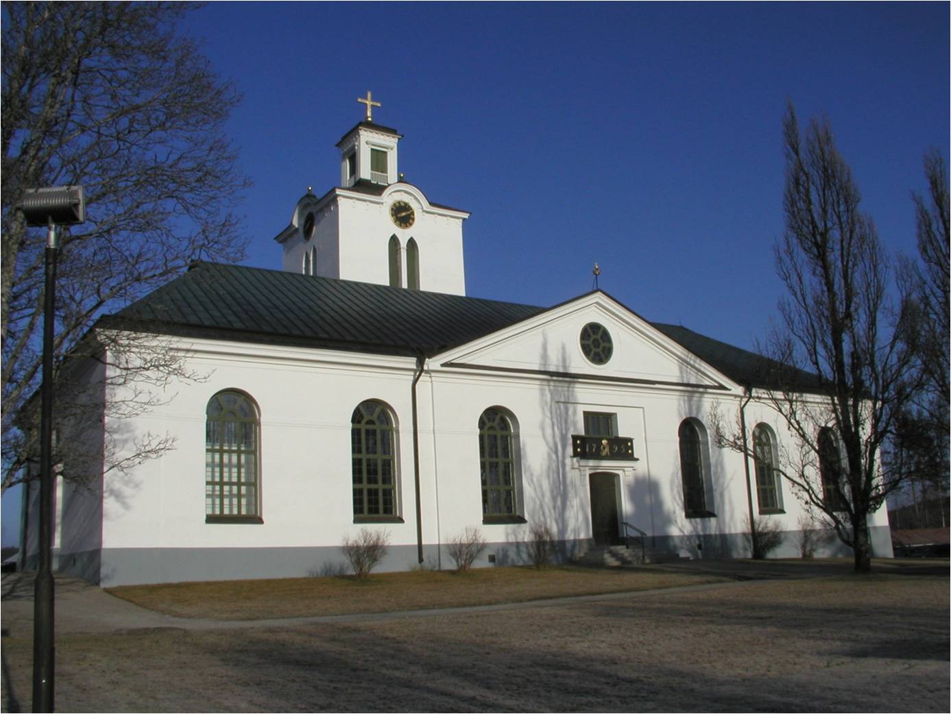 Rengsjö kyrkas södra fasad och del av kyrkotomten.  