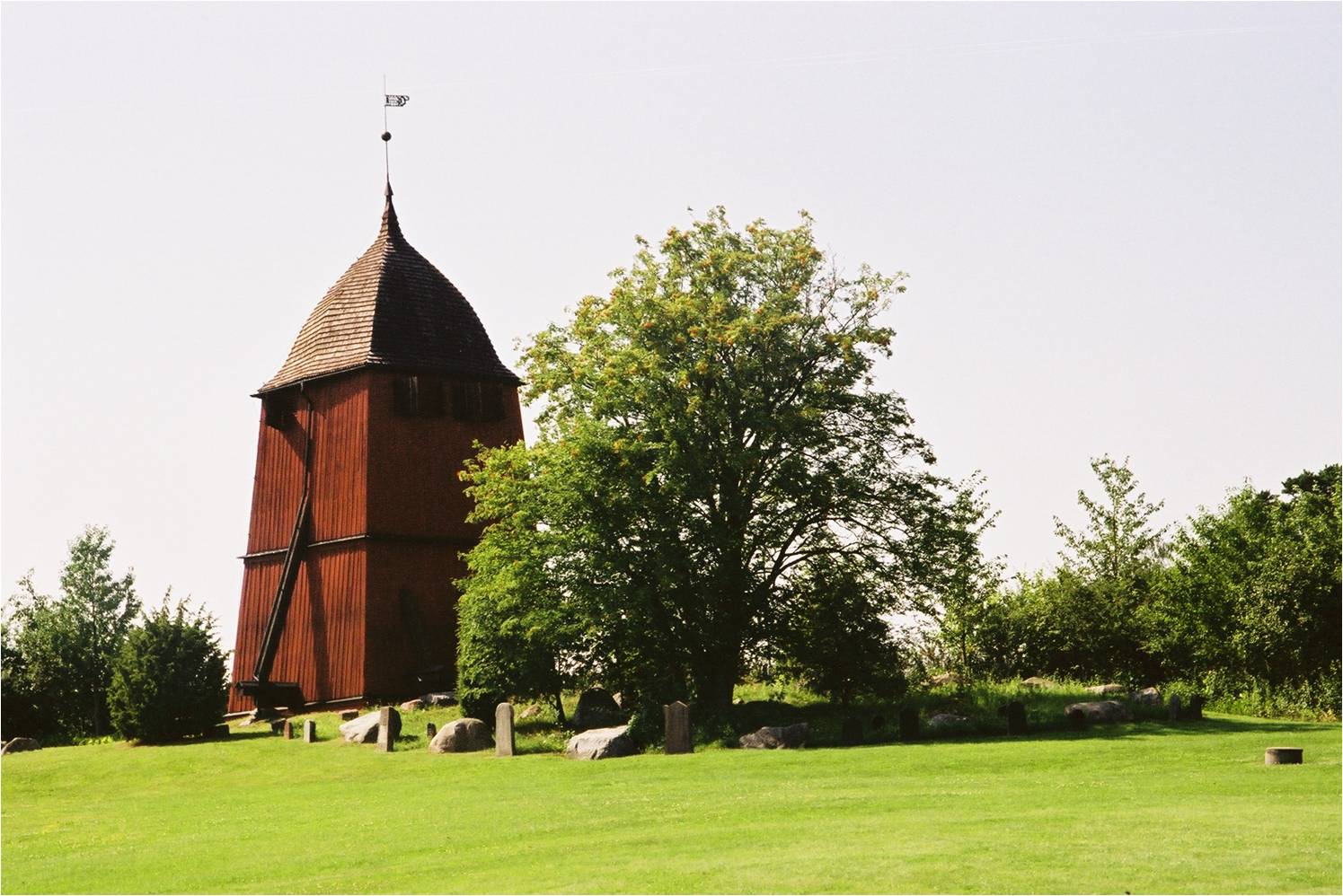Klockstapeln ligger ett par hundra meter väster om kyrka.
Vid klockstapel har ställts upp kulturhistoriskt värdefulla gravvårdar från kyrkogården. 
