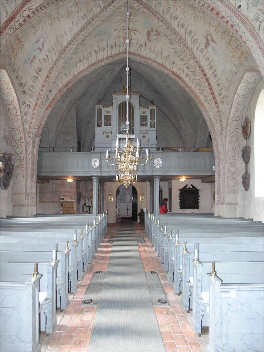 Håtuna kyrka med orgelläktare åt väster. I väst ingång till 1870-talets tillbyggda vapenhus. 