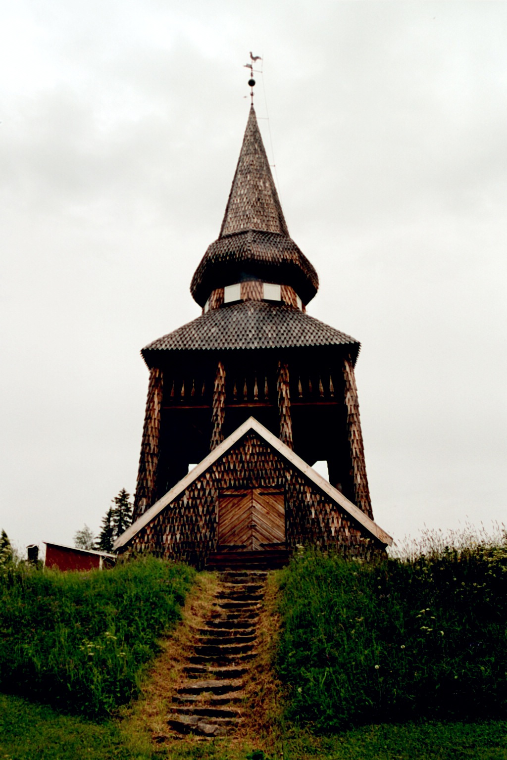 Hackås kyrkas klockstapel. 

På en gräsyta några tiotal meter nordost om kyrkan står en spånklädd, tjärad klockstapel med inbyggd klockbod och spira med ansats till lökkupol. Stapeln är av västjämtländsk typ och uppförd av den namnkunnige byggmästaren Pehr Olofsson från Dillne i Oviken 1750-52. År 2000-01 utfördes en omsorgsfull restaurering av stapeln.