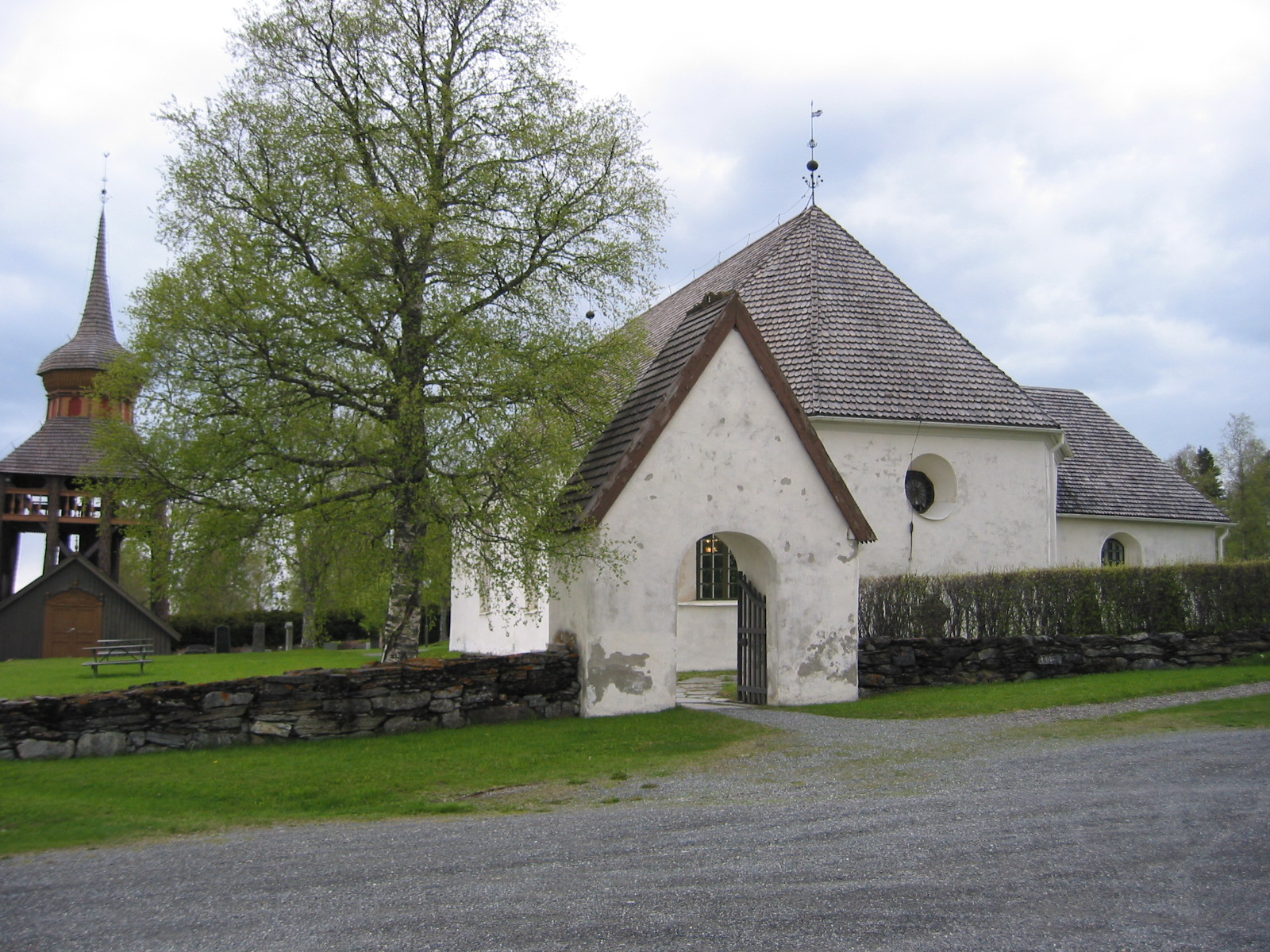 Mattmars kyrka med omgivande kyrkogård med stigport samt klockstapel. 

