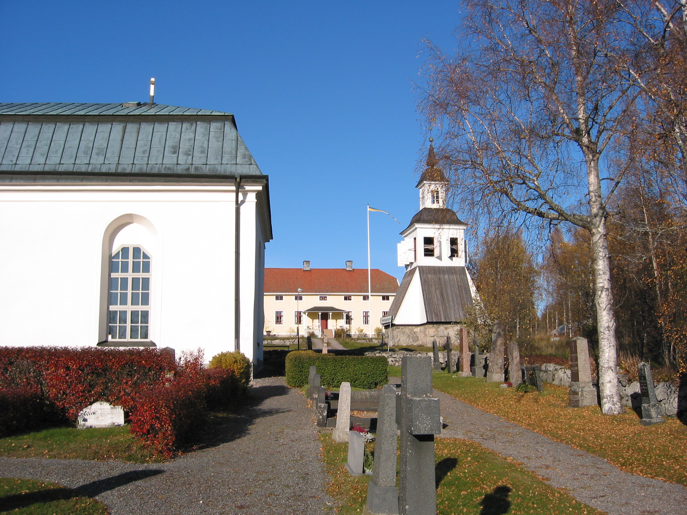 Tynderö kyrkas med omgivande kyrkogård samt klockstapel, vy från söder.  