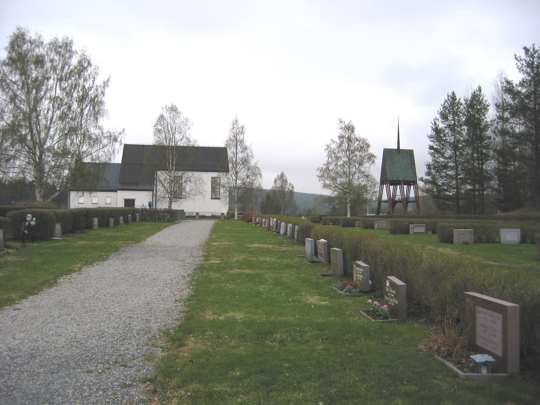 Ånge kyrka med omgivande kyrkogård samt klockstapel, vy från söder.