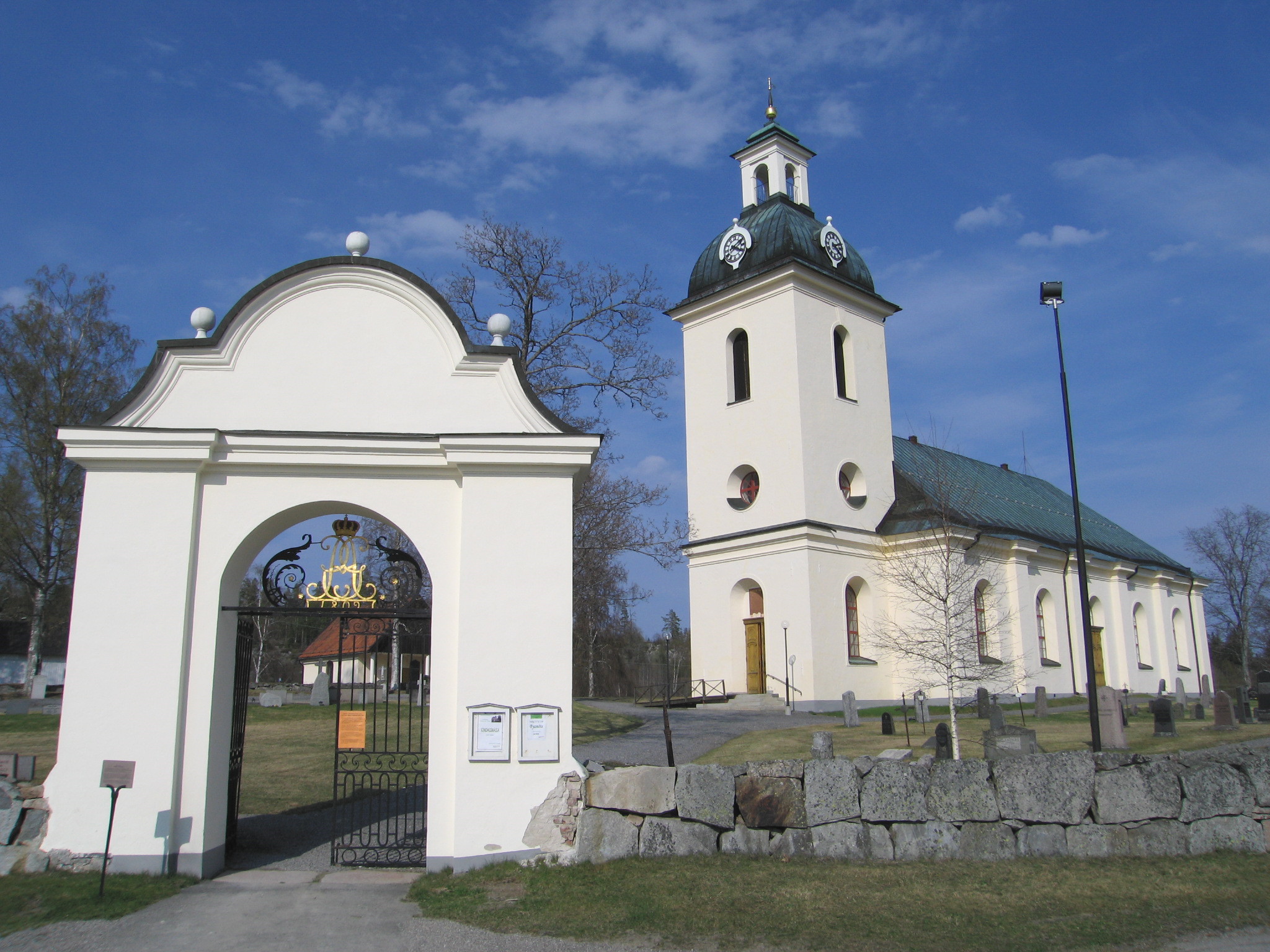 Högsjö kyrka med omgivande kyrkogård samt stigporten, vy från sydväst. 