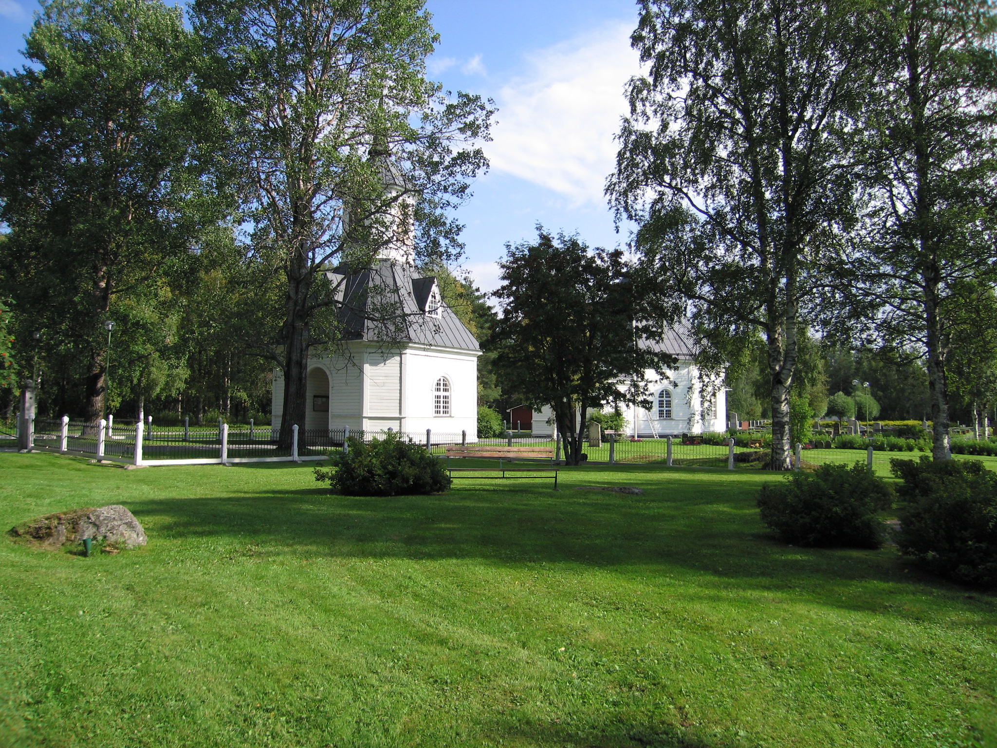 Graninge kyrka med omgivande kyrkogård samt klockstapel, vy från sydväst.