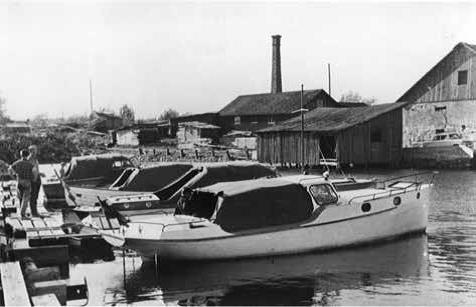 Småbåtar i Sunnanå Hamn. Till höger syns hamnmagasinet
och i bakgrunden tornar en skorsten från det tidigare sågverket
upp. Okänt årtal. Privat samling.