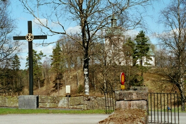 Mikaelskapellet hör till Toarps kyrka, som här ses skymta på sin kulle från kapellanläggningens huvudentré.