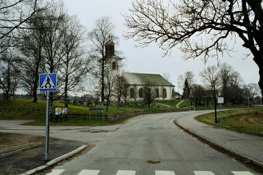 Rångedala kyrka sedd från södra tillfartsvägen med infarten till vänster i bild.