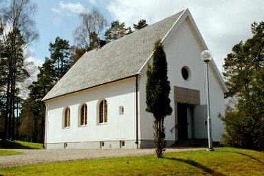 Mikaelskapellet sett från öster mot en mörk fond av tallar. Kapellet stod klart 1942.