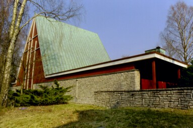 Sjöbo kyrka byggdes 1962 med kalkstensmurar längs långsidorna och en lång utbyggnad med atriumgård åt sydväst. Här ses nordvästra långsidan från väster.