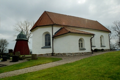 Tärby kyrka sedd från nordöst med klockstapeln i bakgrunden.