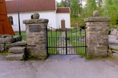 Huvudentrén till Brämhults kyrka har kvar en klivstätta över muren och smidesgrindar från Caroli kyrka i Borås.