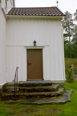 Porten till västra vapenhuset i Brämhults kyrka vetter åt norr. Efter grundens höjning 1951 kompletterades trappan med stenhällar från gårdar i trakten.