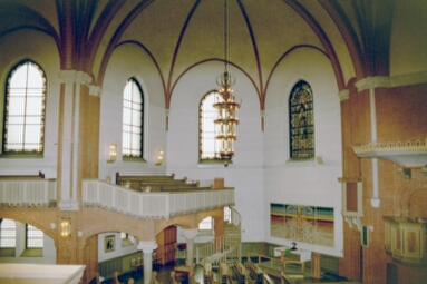 Gustav Adolfs kyrka sedd från södra sidoläktaren ned mot Petruskapellet i norra tvärskeppet .