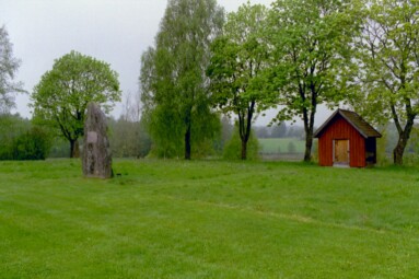 Vid Vänga kyrkogårds norra kant, mot våtmarkerna, står den gamla kyrkans vapenhus och framför denna en minnessten för den gamla stenkyrkans plats. Före den stod här en stavkyrka från 1000-talet.