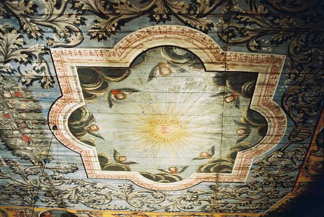 Främre plafonden (ovan koret) av takmålningarna med Jehova i sol mot blå himmel kantad av änglahuvuden i moln.