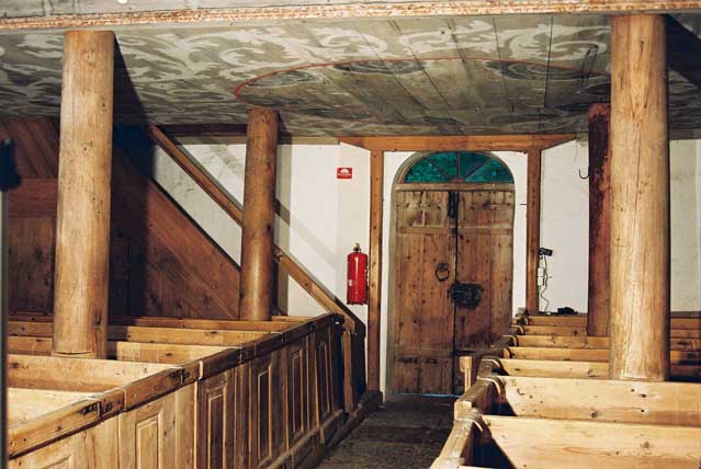 Parti av kyrkorummets västra del med bl a takmålninmgar under läktaren och västra kyrkporten.  