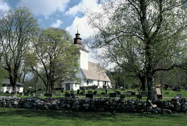 Brattfors kyrka med del av kyrkogårdens sydvästra del. 