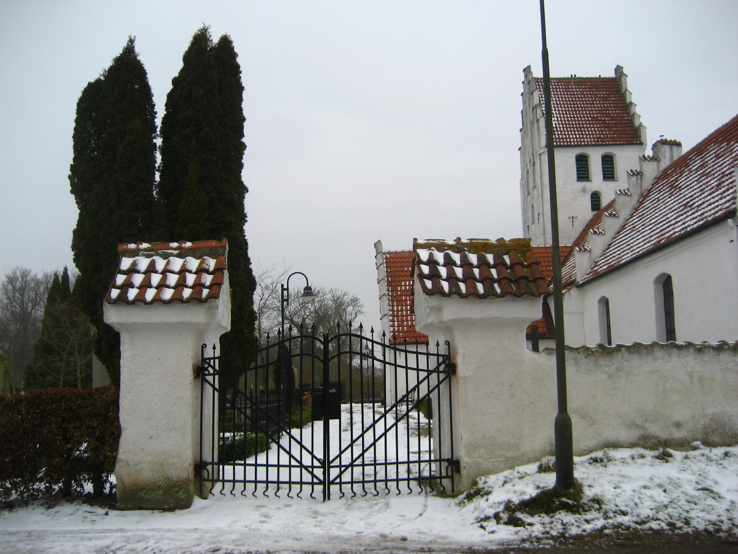 Burlövs kyrkogård med grindstolpar vid östra ingången.