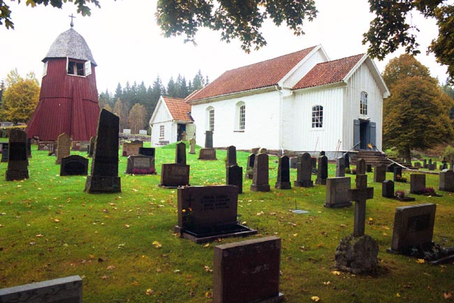 Södra Åsarps kyrka och klockstapel med omgivande begravningsplats.