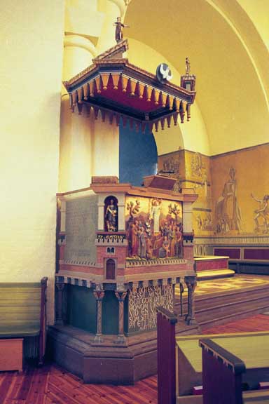Predikstolen i Tranemo kyrka med kormålningar och portal till den gamla sakristian, från SV.



