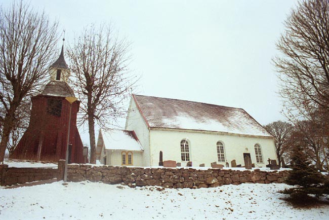 Månstads kyrka med klockstapel och södra kyrkogårdsmur.