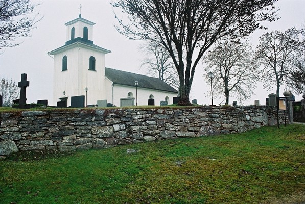 Finnekumla kyrka med den södra kyrkogårdsmuren, från SV.