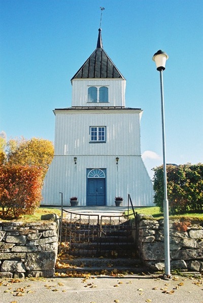 Grönahögs kyrka med smidesgrindar i kyrkogårdsmuren, från väster.