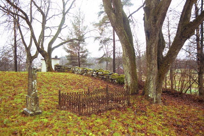 Gravvård inhägnad av smidesstaket på den västra delen av kyrkogården vid Hyssna gamla kyrka.