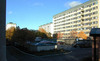 Parkering innanför betongmurar. I förgrunden sophanteringshus. 
SAK00182 Stockholm, Bredäng, Par Bricole 2 Bredängsvägen 228-248 SV 9910 JST