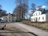 Kuddby kyrka, till vänster f d sockenmagasin, till höger f d kyrkskolan.