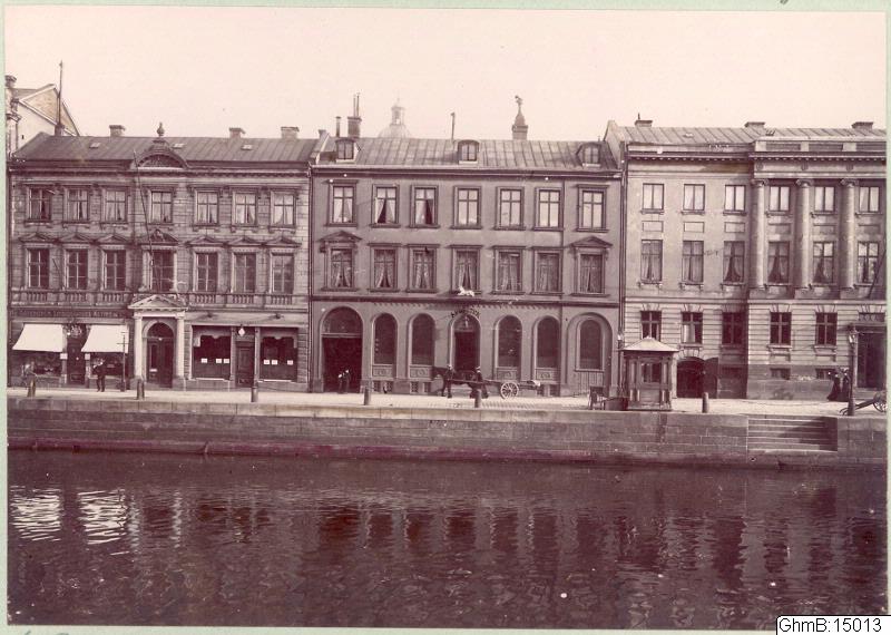 Södra Hamngatan 13-17. Kvarteret med apoteket Enhörningen (rivet) i mitten med rundbågade butiksfönster. Till vänster också rivet hus. Till höger Chalmerska huset.

Inventarienummer: GhmB:15013