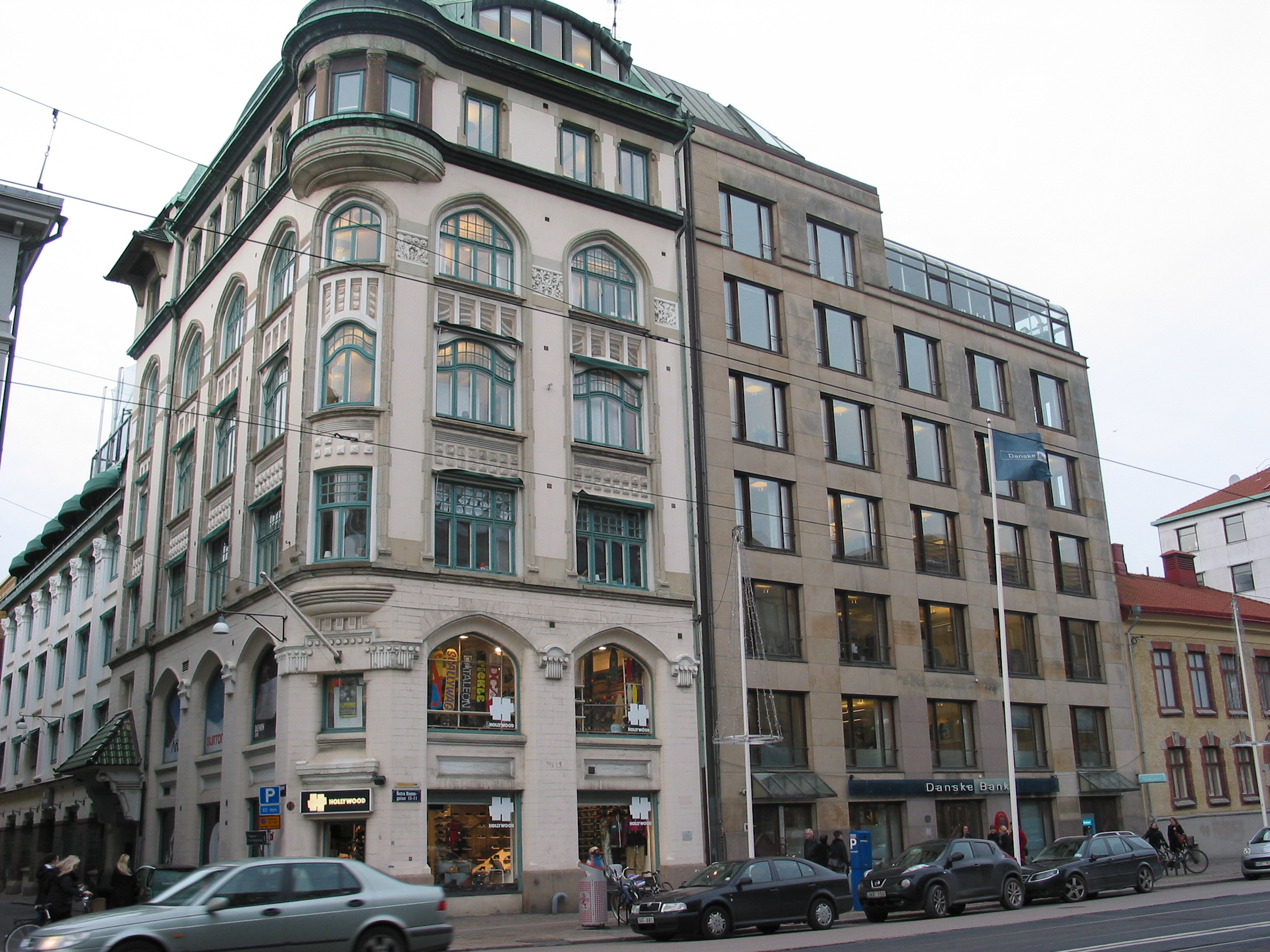 Till vänster kontorshus i jugendstil från 1906, till höger kontorsbyggnad uppförd 1985-86 efter ritningar av White arkitekter genom Birgitta Illes. Den nya byggnaden anpassades till det höga sekelskifteshuset i söder. Taklinjen bryts av ett rundat glasparti, vilket skapar asymmetri i den för övrigt symmetriska fasaden. Fönstren har vinklade sidopartier.
