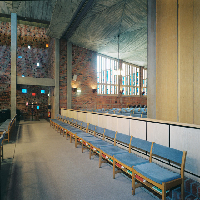 Vantörs kyrka, kyrkorummet med färgade glasblock i den östra väggen. Till höger syns en vikvägg. 
